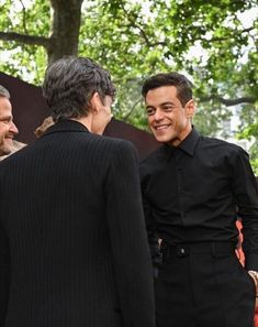 three men in suits are talking to each other