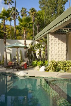 an outdoor swimming pool surrounded by palm trees