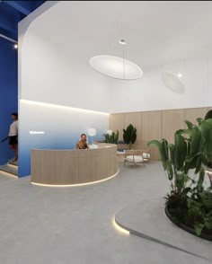 a woman sitting at a reception desk in an office with blue walls and planters