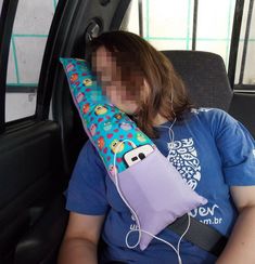 a woman sitting in the back seat of a car holding a pillow