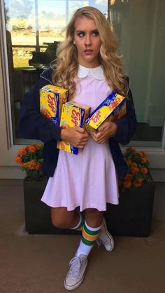 a woman dressed as a girl holding some candy bars in her hands and wearing socks