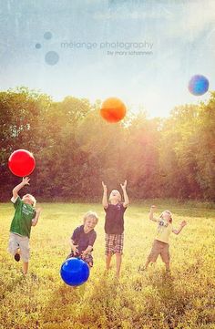 four children playing with frisbees in a field