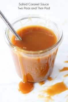 a glass jar filled with liquid and a metal straw sticking out of it's top