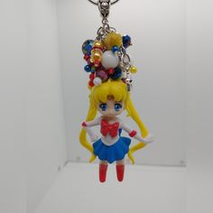 a keychain with a cartoon character wearing a red bow and blue dress on it