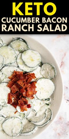 a white bowl filled with cucumber bacon ranch salad on top of a marble counter