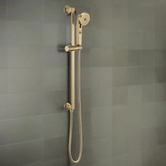 the shower head and handset are mounted to the wall in this bathroom with gray tile