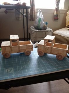 two wooden toy trains on a table in a room