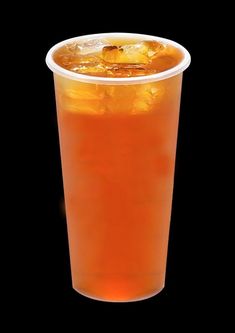 an orange drink in a plastic cup on a black background