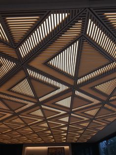 the ceiling is made up of wooden slats and has light coming from above it