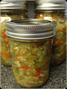 several jars filled with pickles and vegetables