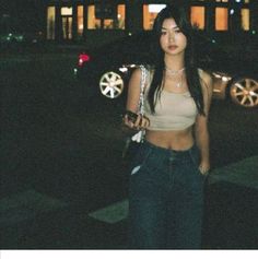 a woman standing in front of a building at night