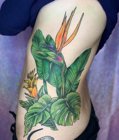 a woman's stomach with a bird of paradise tattoo on it