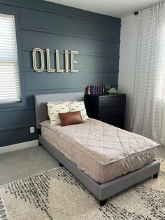 a bed sitting in a bedroom next to a window with blinds on the windowsill