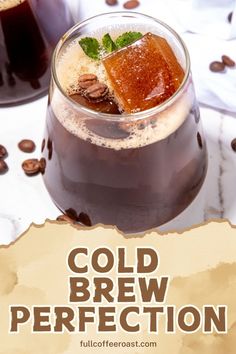 two glasses filled with cold beverages on top of a white table next to coffee beans