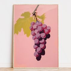 a painting of grapes on a pink background in a room with wood flooring and white walls