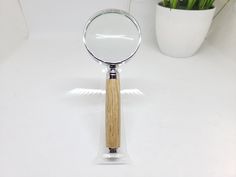 a magnifying glass sitting on top of a table next to a potted plant