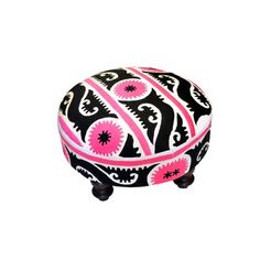 a black and pink ottoman sitting on top of a white floor