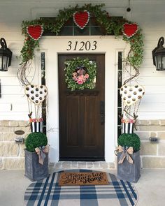 the front door is decorated with wreaths and decorations