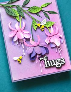 a pink card with flowers and bees on it that says hugs in white lettering, against a blue background