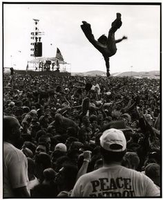 a man doing a handstand in front of a large crowd at a concert