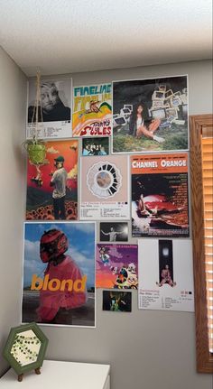 a wall covered in posters and pictures next to a window