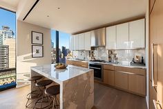 a kitchen with wooden cabinets and white counter tops next to a large window overlooking the city