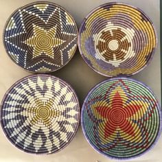 four woven baskets with different designs on them