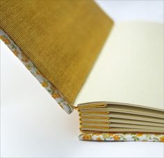 an open book with yellow and white flowers on it