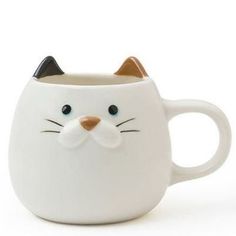 a white coffee mug with a cat's face on it