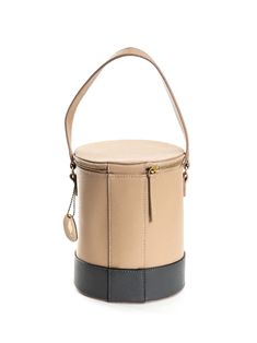 a small tan and black bucket bag on a white background