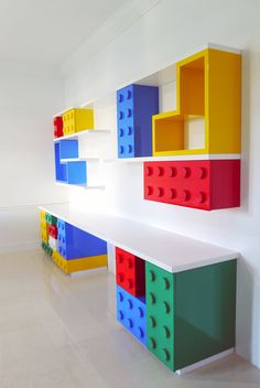 colorful legos are stacked on top of each other in the corner of a room