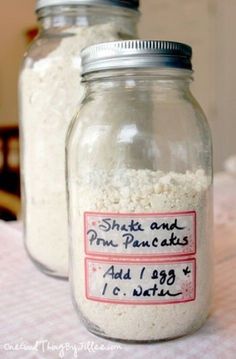 two glass jars filled with white rice sitting on top of a table