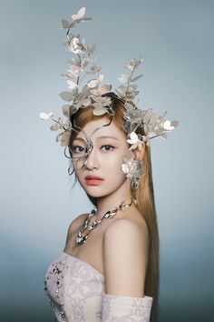 a woman with long hair and flowers in her hair, wearing a tiara made out of leaves