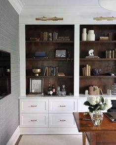 a living room filled with lots of bookshelves next to a desk and chair