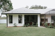 a small white house sitting on top of a lush green field