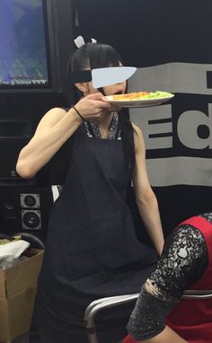 a woman holding a plate with food on it