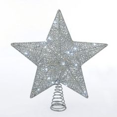 a silver star ornament hanging from a spiral christmas tree topper on a white background