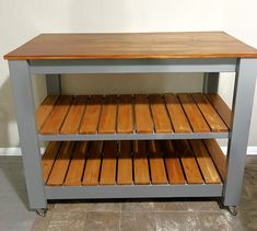 a kitchen island made out of metal and wood with two shelves on each side that hold wooden planks