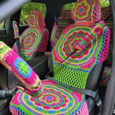 colorful crocheted seat covers in the back of a car, with steering wheel