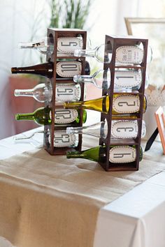 wine bottles are stacked on top of each other at the end of a dining table