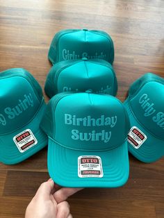 a person pointing at five hats on top of a wooden table with the words birthday sulfy written on them