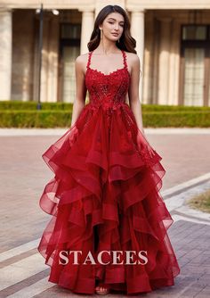 a woman in a red dress standing on the street