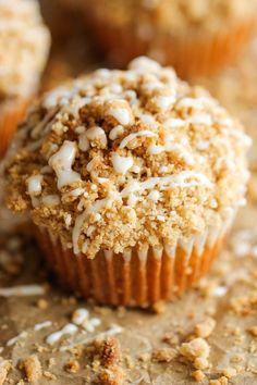 a muffin with white frosting and sprinkles sitting on a table