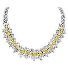 A rare diamond necklace, showcasing one row of graduating radiant cut diamonds weighing 23.45 carats total certified by GIA as Fancy Intense Yellow color, set on 18K yellow gold. Accented by marquise and round brilliant cut diamonds weighing 62.82 carats total, set on platinum in an intricate design. Inner circumference: 14 inches. Roman Malakov is a custom house, specializing in creating anything you can imagine. If you would like to receive a special quote on a custom piece, please message or Luxury Yellow Gold Diamond Necklace For Engagement, Luxury Yellow Diamond Necklace, Luxury Yellow Fine Jewelry Necklace, Luxury Yellow Gold Diamond Necklace With 17 Jewels, Elegant Luxury Yellow Temple Necklace, Yellow Diamond Necklace, White Diamond Necklace, Rare Diamond, Gia Certificate