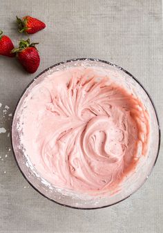 strawberry cream cheese frosting in a bowl with strawberries on the side and text overlay