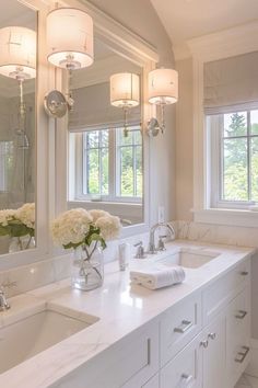 a bathroom with two sinks and three mirrors