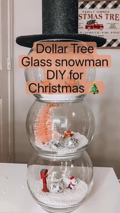 a snowman is sitting on top of a glass bowl with christmas decorations in it and the words dollar tree glass snowman diy for christmas