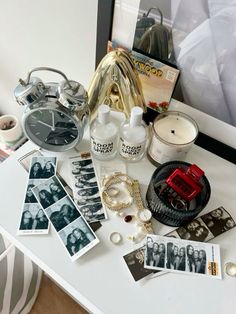 an assortment of personal items on a table next to a framed photograph and other things