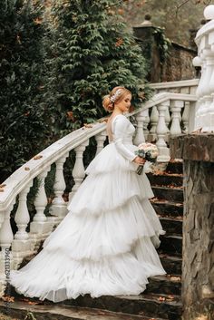 a woman in a wedding dress standing on some stairs