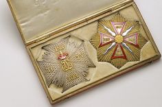 an old gold pocket with two medals on the front and one has a cross in it